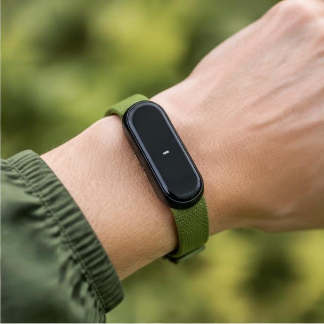 An activity sensor with a green wrist strap